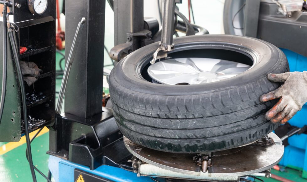Series of worker removing tire from rim with tire removal machinery equipment